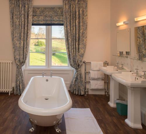 uma casa de banho com 2 lavatórios e uma grande janela em Hall Bed & Breakfast em Bishops Tawton