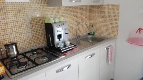 a kitchen with a coffee maker on a counter next to a sink at B&B D'Amare in San Salvo