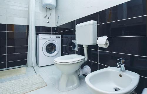 uma casa de banho com um WC e uma máquina de lavar roupa em Apartment Mešin em Split