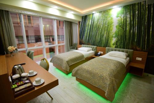 two beds in a hotel room with green lights at Quantum Hotel in Trabzon