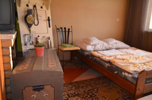 a bedroom with a bed and a table in it at Farebný Penzión in Krásnohorské Podhradie