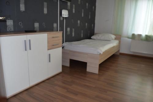 ein kleines Schlafzimmer mit einem Bett und einer Kommode in der Unterkunft Stuttgart Wohnung Ost in Stuttgart