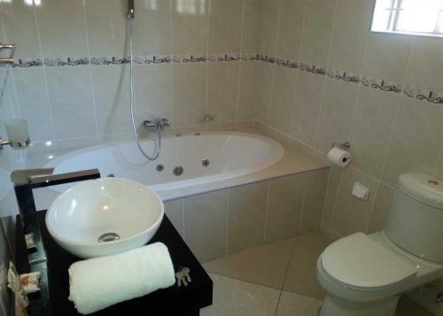 Sibasa的住宿－Masili Guesthouse & Conference，带浴缸、卫生间和盥洗盆的浴室