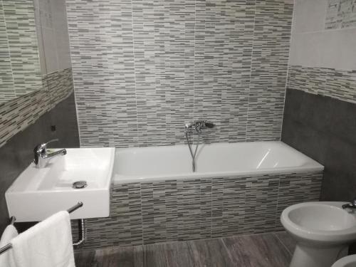 een badkamer met een wastafel, een bad en een toilet bij Hotel Primavera in Napels