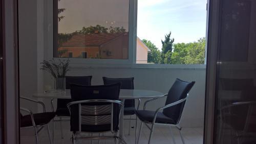 a table and chairs in a room with a window at Apartmani Gaj in Malinska
