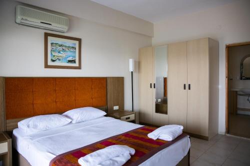 GuvercinlikにあるGreenport Bodrum Hotelのベッドルーム1室(大型ベッド1台、タオル2枚付)
