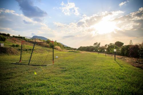 a field with a net in the grass at Abbaidda Hotel in Valledoria