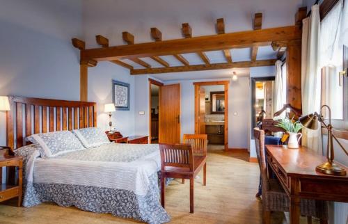 a bedroom with a bed and a desk and a table at Casa Rural Haritzpe in Hondarribia