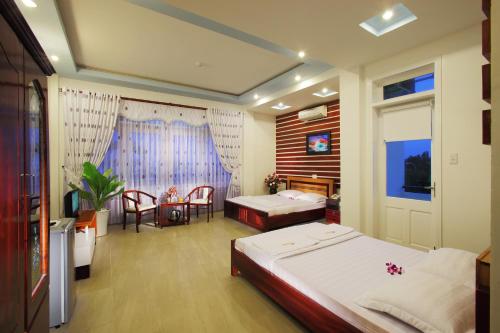 1 dormitorio con 2 camas, mesa y silla en Gold Stars Hotel, en Long Hai