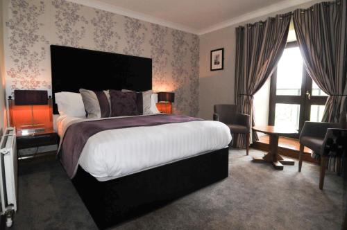 a bedroom with a large bed and a large window at The Hillcrest Hotel in Widnes