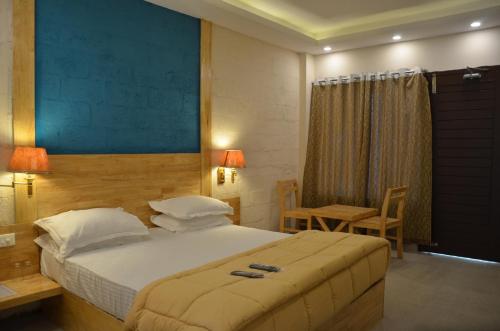 a bedroom with a bed and a table and a chair at Coconhuts Beach Resort in Neil Island
