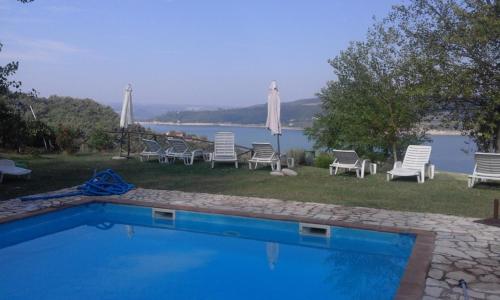 a swimming pool with chairs and a view of the water at Poggio San Giacomo in Baschi