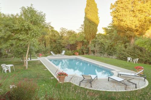 einen Pool im Garten mit Stühlen und einem Tisch in der Unterkunft Le Stanze di Ebe in Lucignano