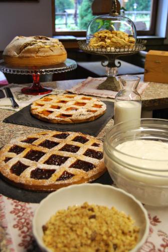 una tabella ricoperta di torte e altri prodotti alimentari di Villa Ruggero Wine Hotel a Campitello di Fassa