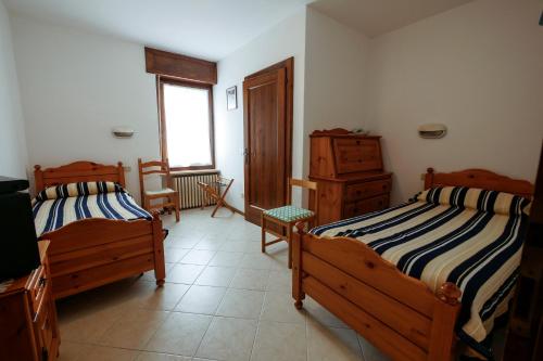 ファッラ・ダルパーゴにあるAlbergo De Marchのベッドルーム1室(ベッド2台、窓付)