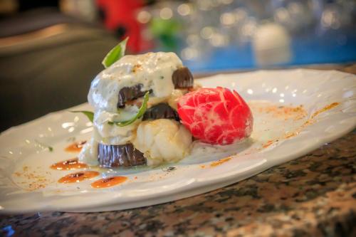a dessert on a white plate with a strawberry at Abbaidda Hotel in Valledoria