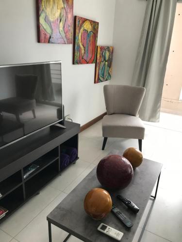 a living room with a tv and a table at Olivos Suites in Olivos
