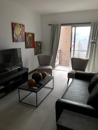a living room with a couch and a tv at Olivos Suites in Olivos