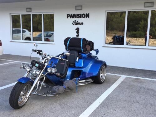 a blue motorcycle parked in a parking lot at Rooms & Pansion Odmor in Rovanjska