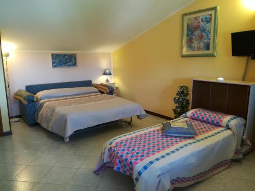 a hotel room with two beds and a tv at Mon Refuge Villa Deluxe in Correzzola