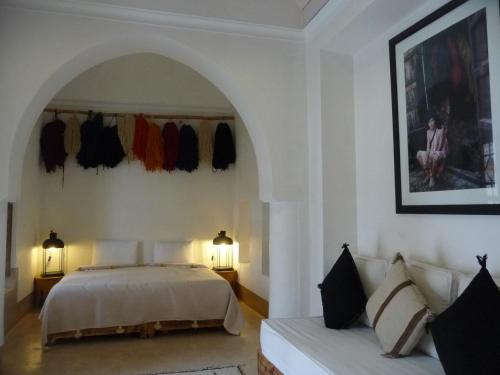 a bedroom with a bed and two lamps and a couch at Riad Matham in Marrakech