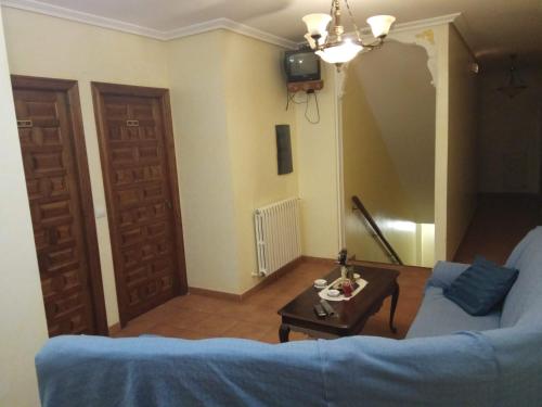 salon z niebieską kanapą i stołem w obiekcie Hostal Restaurante Raton w mieście Paredes de Nava