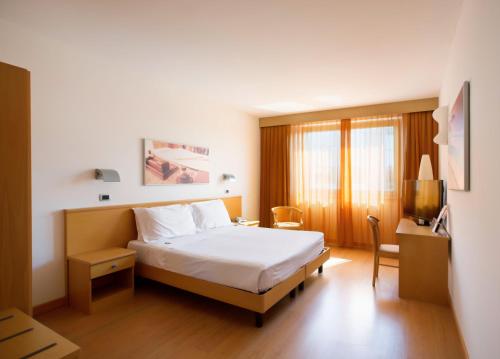 una camera d'albergo con letto e TV di Hotel Montemezzi a Vigasio