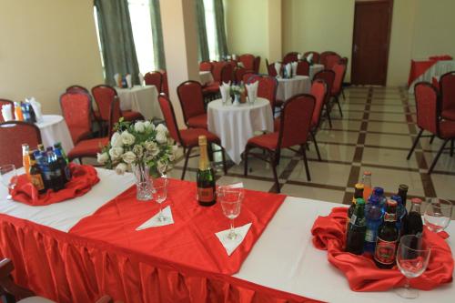 a room with tables and chairs with wine bottles at Hera Addis Hotel in Addis Ababa