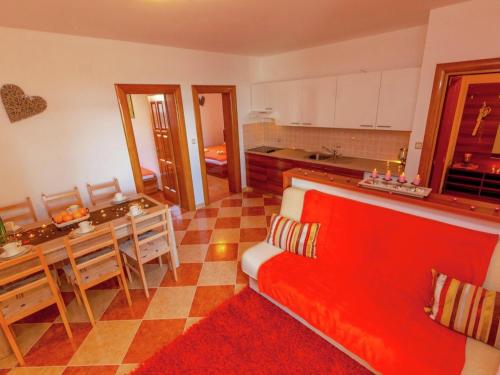 sala de estar con sofá rojo y cocina en Tasteful Apartment in Dramalj with Swimming Pool, en Dramalj