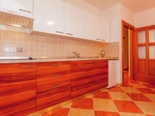 cocina con armarios de madera y suelo a cuadros en Tasteful Apartment in Dramalj with Swimming Pool, en Dramalj