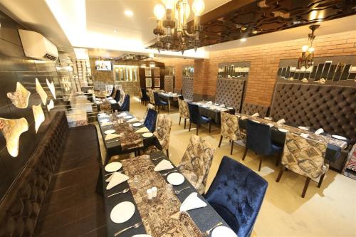 a dining room with long tables and blue chairs at Hotel President in Nagpur