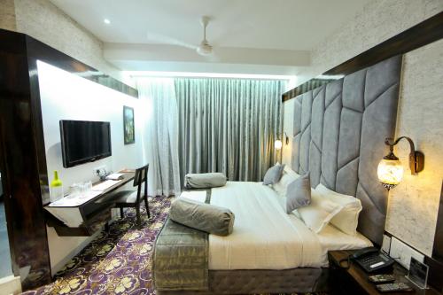 a hotel room with a large bed and a desk at Hotel President in Nagpur