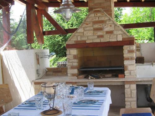 a table with plates and glasses and a fireplace at Attractive holiday home in Vabriga in Vabriga