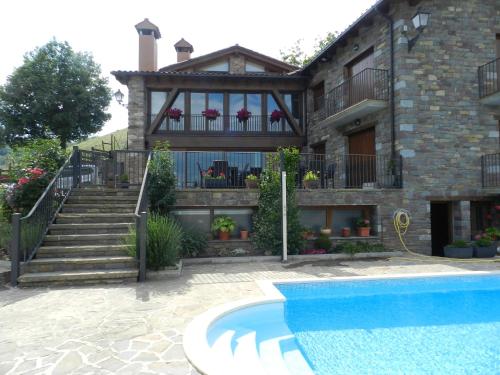 a house with a swimming pool in front of it at Apartaments El Tossalet in Bonansa