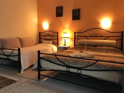 two beds in a bedroom with two lamps on the wall at Corali in Menídion