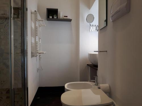een witte badkamer met een toilet en een wastafel bij Kukkiti in Ragusa
