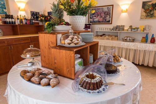 a table with a white table cloth with food on it at Albergo Villa A Mare in Peschici
