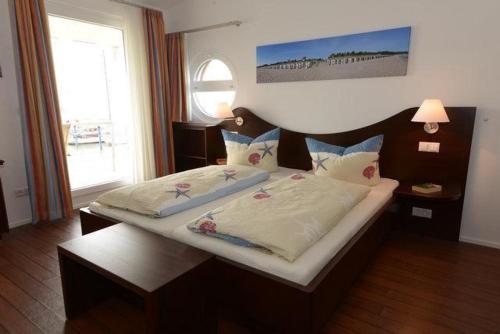 a bedroom with a large bed with a wooden headboard at Ruegen in Wiek auf Rügen