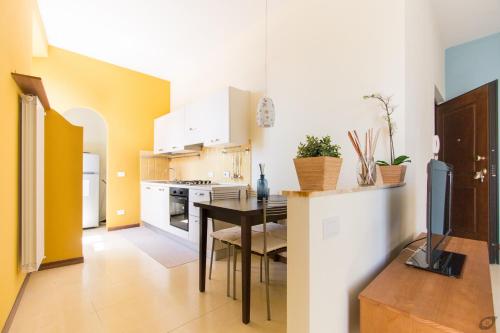 a kitchen with a table and a kitchen with yellow walls at B&B La Sosta degli Artisti in Pietrasanta