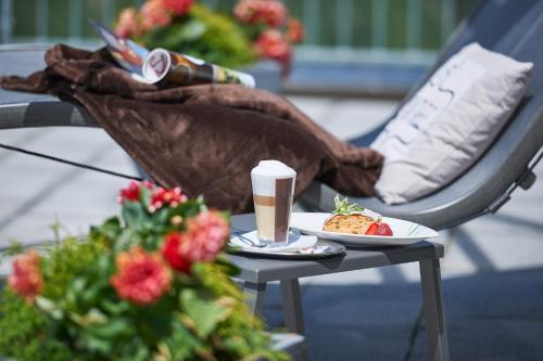 a table with a plate of food and a cup of coffee at Alpenhotel Laurin in Hochgurgl