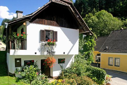 a white house with a window with flowers on it at Landhotel Neugebauer in Löllinggraben