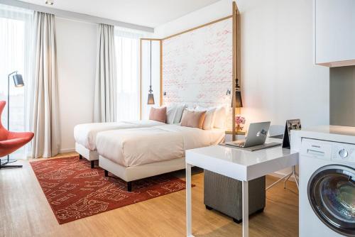 pokój hotelowy z łóżkiem i pralką w obiekcie Capri by Fraser Berlin w Berlinie