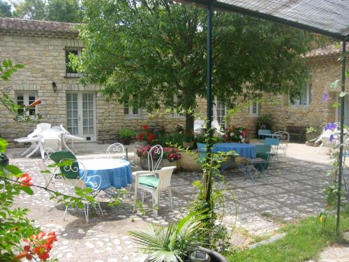 een patio met een tafel en stoelen voor een gebouw bij Moulin d'Antelon B&B in Crillon-le-Brave