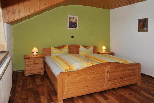 ein Schlafzimmer mit einem großen Holzbett mit zwei Nachttischen in der Unterkunft Ferienhof Fink - Ferienwohnung Kleeblatt in Opfenbach