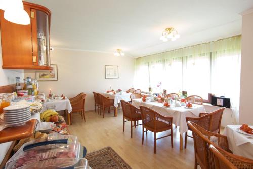 a dining room with white tables and chairs at Hotel Reinhardtshof Garni in Wolfschlugen