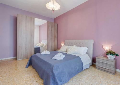 ローマにあるNinuphar Maisonの紫の壁のベッドルーム1室、ベッド1台(タオル付)