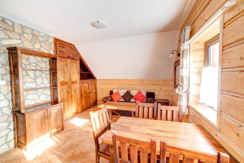 a room with a table and chairs and a couch at Solny - Resort w Bieszczadach in Cisna