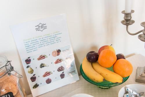 a bowl of fruit on a counter next to a menu at B&B La Sosta degli Artisti in Pietrasanta