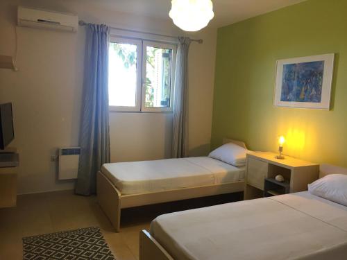 a small room with two beds and a window at Big Blue Villa Porto Heli in Porto Heli