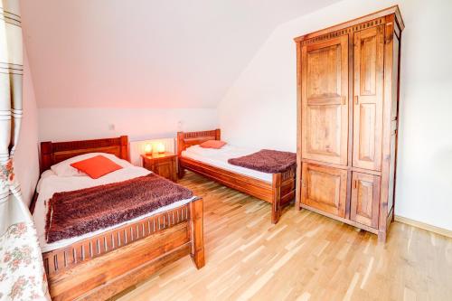 a bedroom with two beds and a cabinet at Solny - Resort w Bieszczadach in Cisna